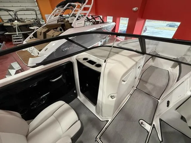 Slide: The Image of 2025 Yamaha Boats AR250 interior, featuring sleek seating and modern design in a showroom setting. - 10