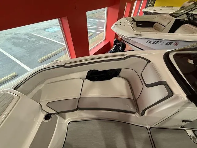 Slide: The Image of 2025 Yamaha Boats AR250 interior with sleek seating design in showroom. - 14