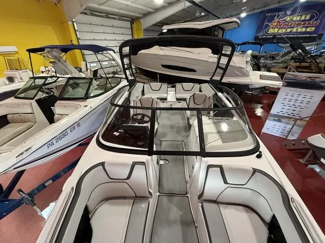 Slide: The Image of 2025 Yamaha Boats AR250 in showroom, sleek design, spacious seating, modern features. - 15