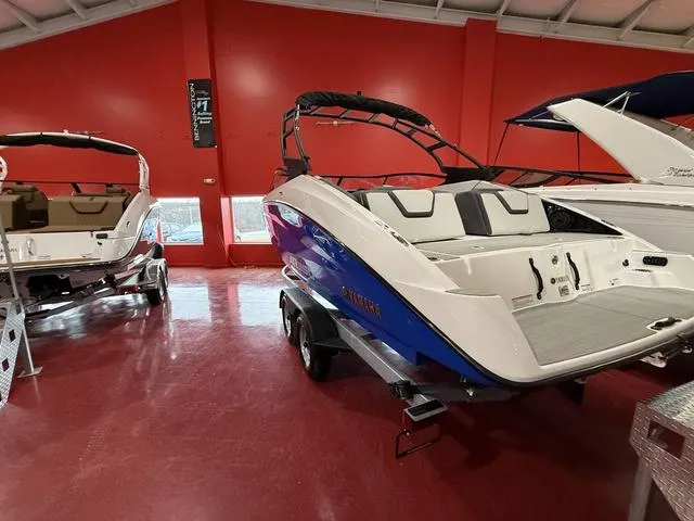 Slide: The Image of 2025 Yamaha Boats AR250, rear view in showroom, showcasing seating and deck design. - 4