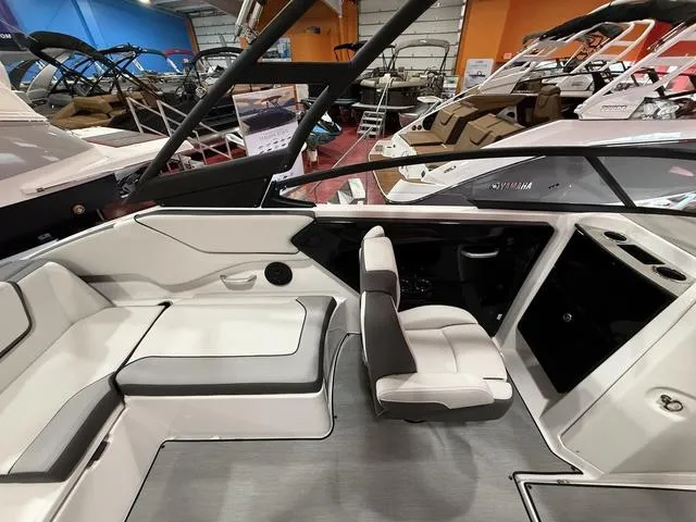 Slide: The Image of 2025 Yamaha Boats AR250 interior with sleek seating and modern design at a boat show. - 7