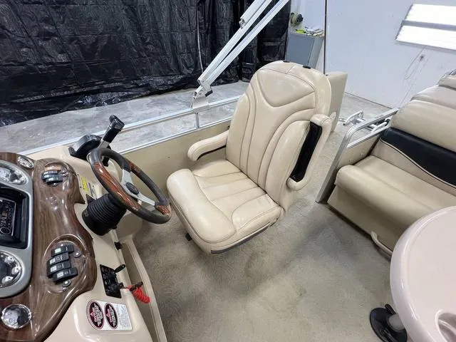 Slide: The Image of 2007 Harris Classic 240 I/O boat interior with beige captain's chair and steering console. - 11