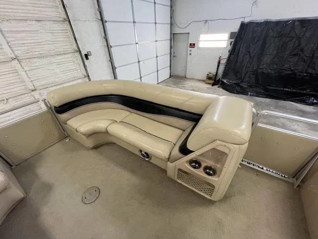Slide: The Image of 2007 Harris Classic 240 I/O boat interior with beige seating in a garage. - 26