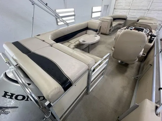 Slide: The Image of 2007 Harris Classic 240 I/O pontoon boat interior with beige seating and Honda engine. - 9