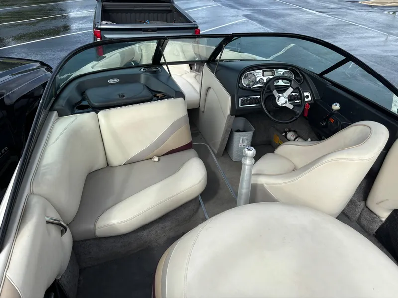 Slide: The Image of Interior of a 2007 Malibu iRide boat with beige seating and steering console. - 10