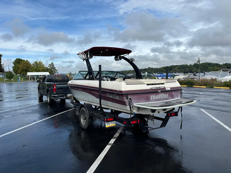 Slide: The Image of 2007 Malibu iRide boat on trailer in parking lot, overcast sky. - 3