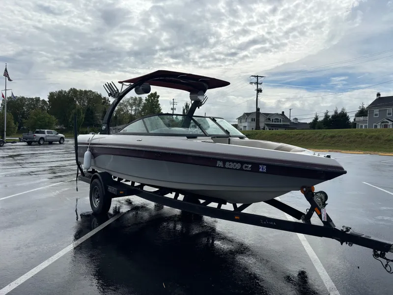 Slide: The Image of 2007 Malibu iRide boat on trailer in parking lot, overcast sky. - 6