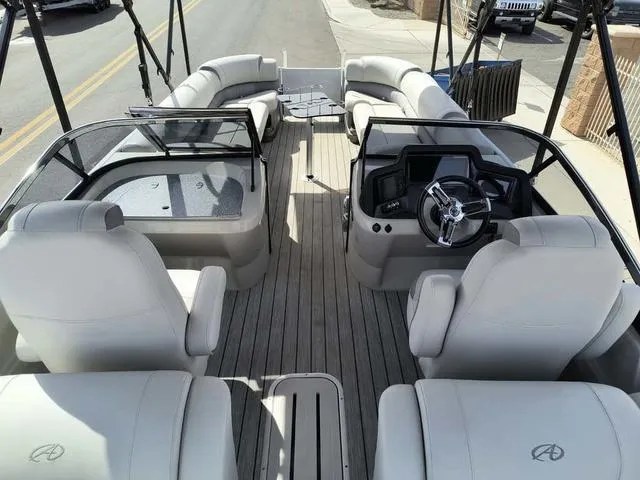 Slide: The Image of 2018 Avalon Excalibur Quad Lounge Windshield 27' pontoon boat with luxurious seating and modern dashboard. - 25