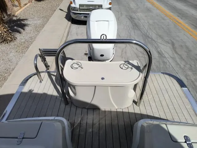 Slide: The Image of 2018 Avalon Excalibur Quad Lounge boat with outboard motor on a street. - 31