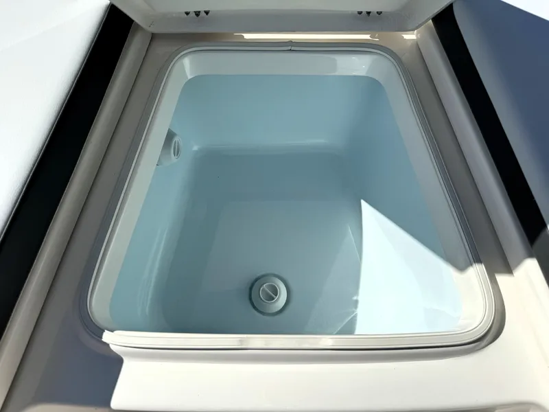 Slide: The Image of Livewell compartment on 2025 Robalo 226 Cayman boat, open lid, white interior. - 18