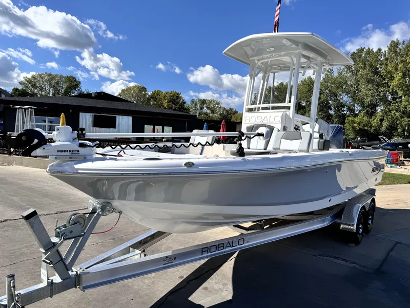 Slide: The Image of 2025 Robalo 226 Cayman boat on trailer under clear blue sky. - 2
