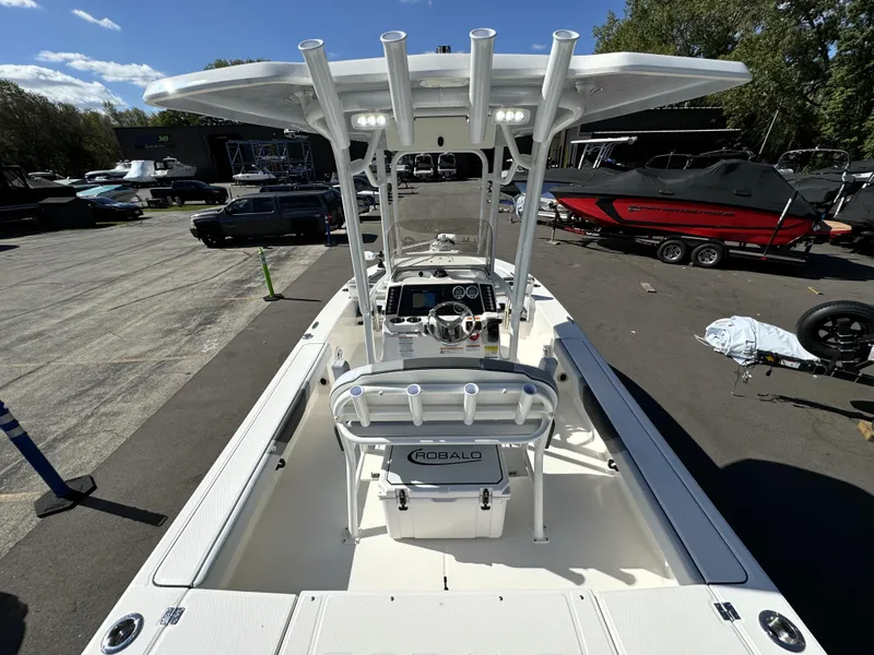Slide: The Image of 2025 Robalo 226 Cayman boat with T-top, docked outdoors under clear skies. - 5
