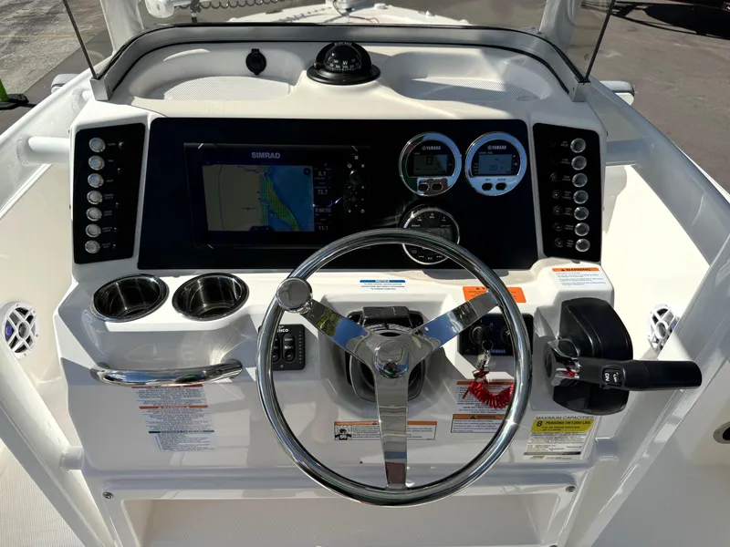 Slide: The Image of 2025 Robalo 226 Cayman boat dashboard with steering wheel and navigation controls. - 9