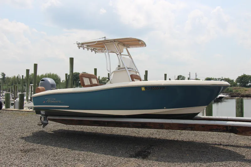 Slide: The Image of 2022 Pioneer 202 Sportfish boat on trailer, blue hull, dockside view. - 1