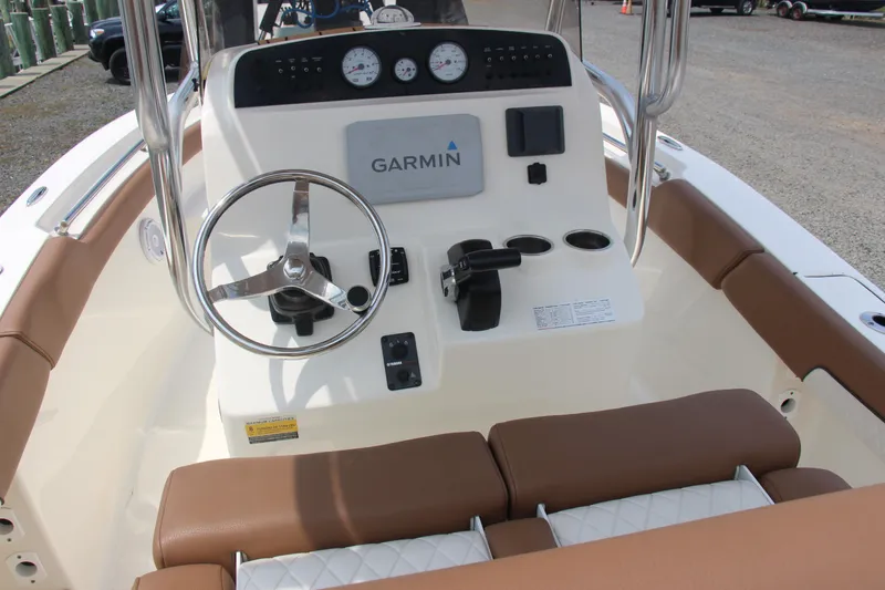 Slide: The Image of Pioneer 2022 202 Sportfish boat dashboard with Garmin navigation system and brown seating. - 6