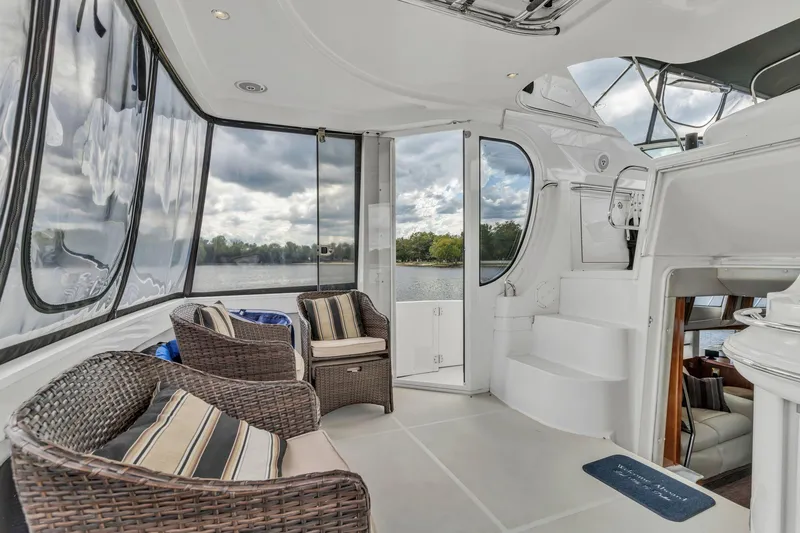 Slide: The Image of Luxurious 2004 Carver 466 Motor Yacht interior with wicker seating and scenic water view. - 19