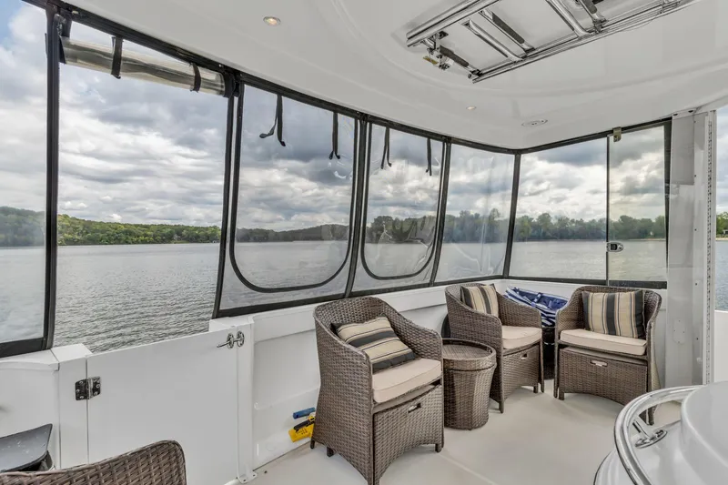Slide: The Image of Spacious deck of 2004 Carver 466 Motor Yacht with wicker seating and scenic lake view. - 20