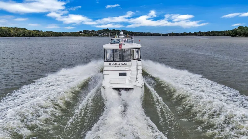 Slide: The Image of 2004 Carver 466 Motor Yacht cruising on a scenic lake. - 3