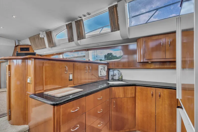 Slide: The Image of Luxurious 2004 Carver 466 Motor Yacht kitchen with sleek wood cabinetry and modern design. - 31