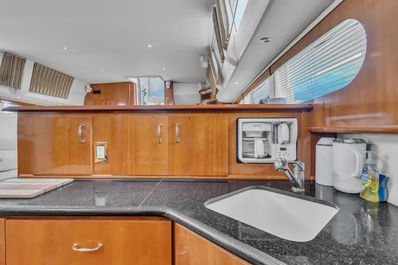 Slide: The Image of Luxurious kitchen interior of 2004 Carver 466 Motor Yacht with wood cabinetry and modern appliances. - 33