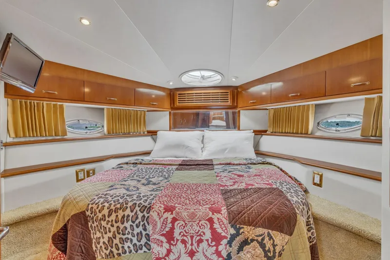 Slide: The Image of Luxurious 2004 Carver 466 Motor Yacht bedroom with elegant wood cabinetry and cozy bedding. - 37