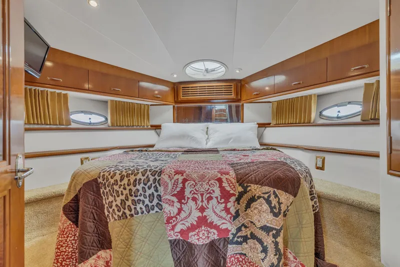 Slide: The Image of Luxurious bedroom in 2004 Carver 466 Motor Yacht with elegant wood cabinetry and colorful quilt. - 38