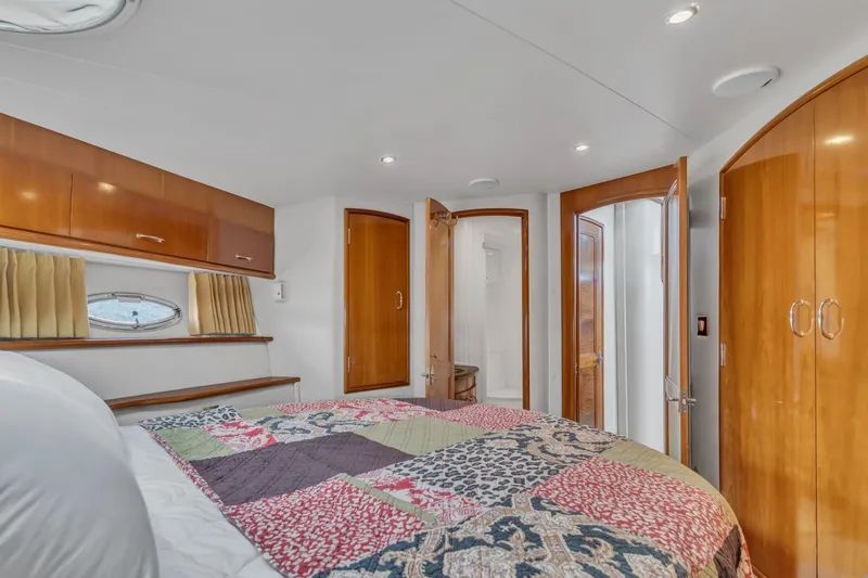 Slide: The Image of Interior of 2004 Carver 466 Motor Yacht bedroom with quilted bedspread and wooden cabinetry. - 40