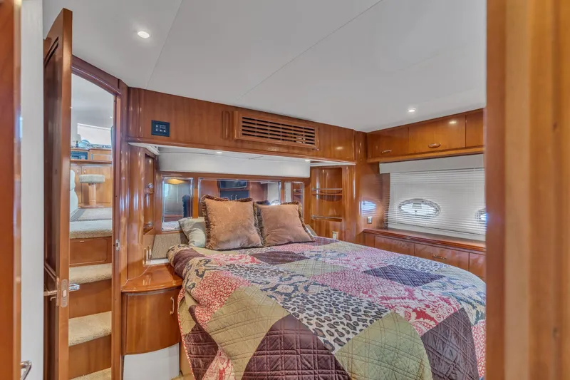 Slide: The Image of Luxurious bedroom interior of 2004 Carver 466 Motor Yacht with wood paneling and cozy bedding. - 46