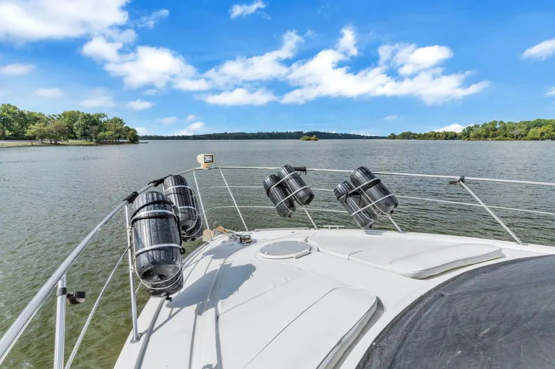 Slide: The Image of Carver 466 Motor Yacht 2004 cruising on a serene lake under a clear blue sky. - 8