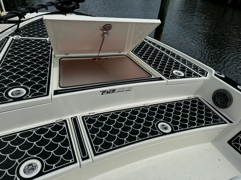 Slide: The Image of 2024 Pathfinder 2500 Hybrid boat deck with open storage compartment, black and white design. - 10