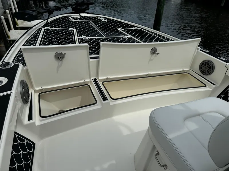 Slide: The Image of 2024 Pathfinder 2500 Hybrid boat with open storage compartments on deck. - 12