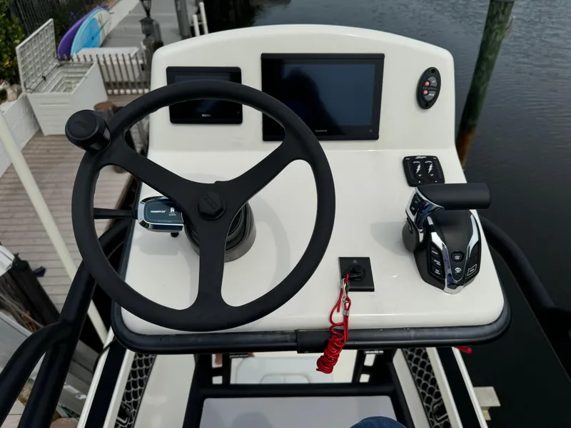 Slide: The Image of 2024 Pathfinder 2500 Hybrid boat helm with steering wheel and controls. - 18