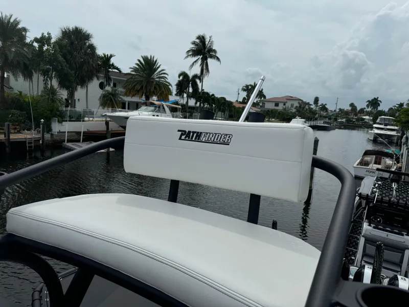Slide: The Image of 2024 Pathfinder 2500 Hybrid boat seat overlooking a scenic canal with palm trees. - 20