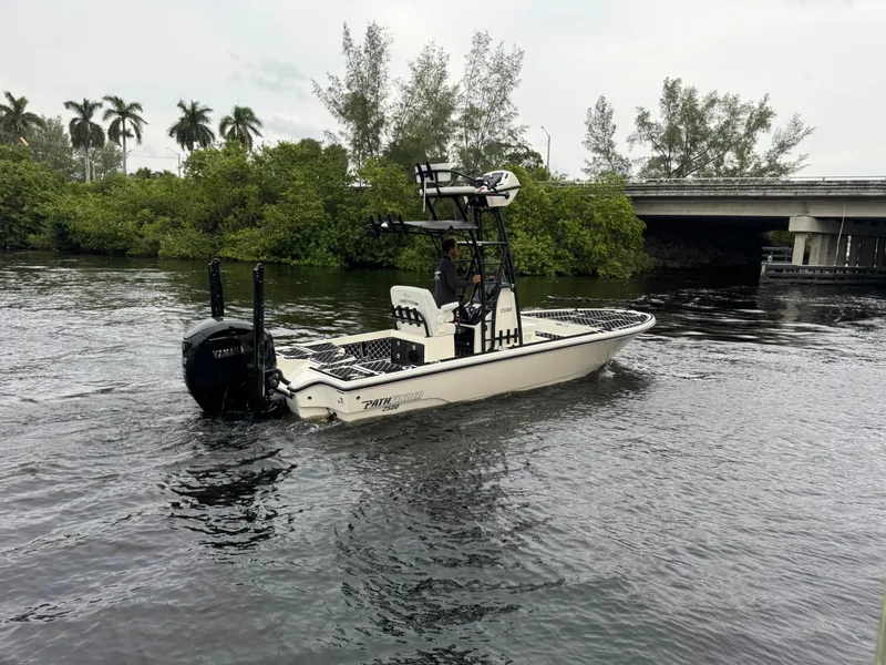 Slide: The Image of 2024 Pathfinder 2500 Hybrid boat on water near bridge and trees. - 3