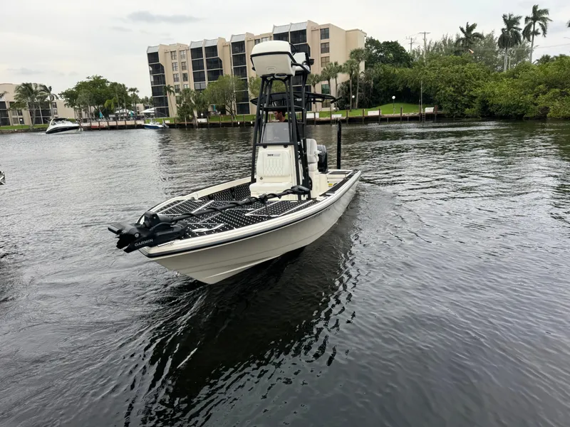 Slide: The Image of 2024 Pathfinder 2500 Hybrid boat on a calm river near modern buildings. - 6