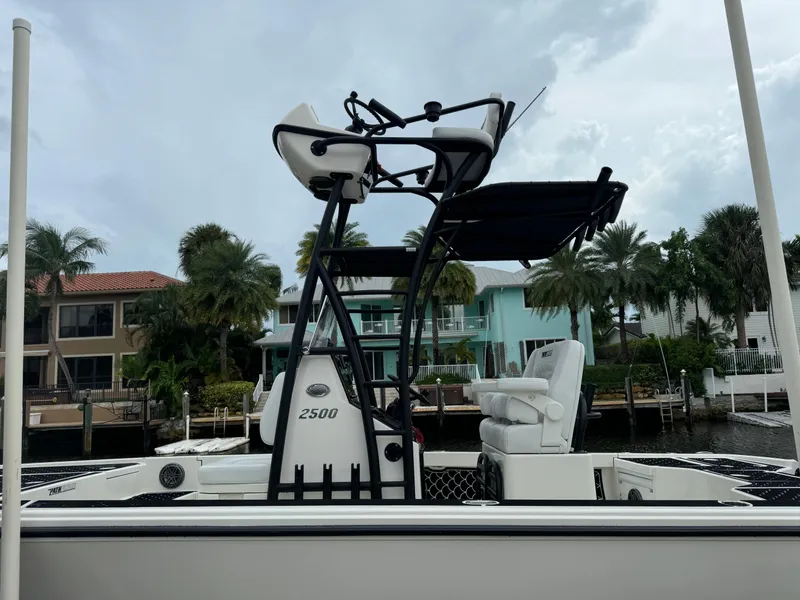 Slide: The Image of 2024 Pathfinder 2500 Hybrid boat docked near waterfront homes. - 7