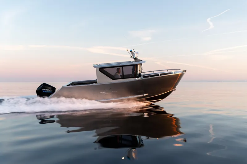 Slide: The Image of Jasper Marine Defender 22 boat cruising on calm water at sunset, 2025 model. - 13