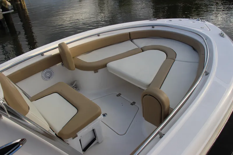 Slide: The Image of 2020 Pioneer 222 Sportfish boat interior with cushioned seating and storage compartments. - 10