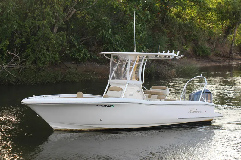 Slide: The Image of 2020 Pioneer 222 Sportfish boat on calm river near lush greenery. - 9