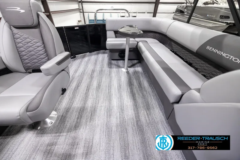 Slide: The Image of 2025 Bennington 21 SL boat interior with gray seating and carpet, featuring a small table. - 15