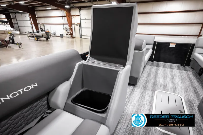 Slide: The Image of 2025 Bennington 21 SL boat interior with open storage compartment in a showroom. - 22