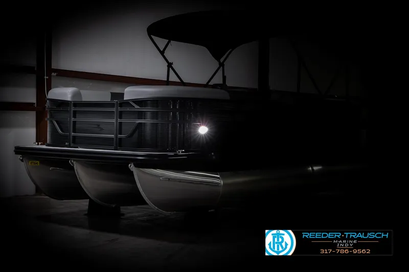 Slide: The Image of 2025 Bennington 21 SL pontoon boat in dimly lit showroom. - 5