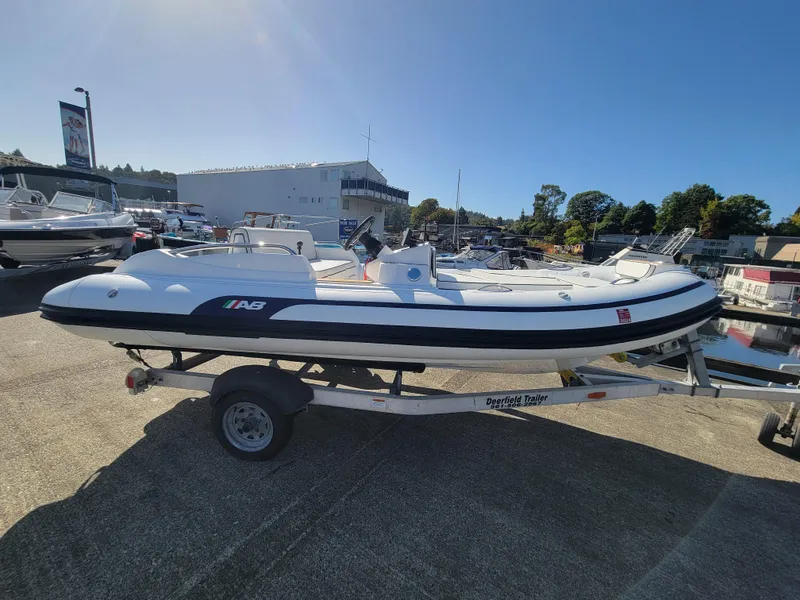 Slide: The Image of 2021 AB Inflatables ABJET 430XP boat on trailer, parked outdoors in a marina setting. - 11