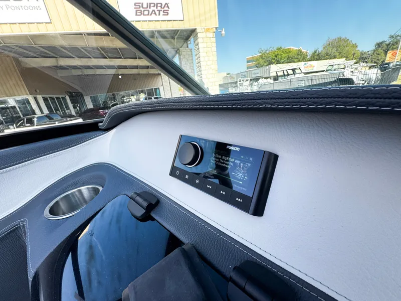 Slide: The Image of 2025 Regal LS4 boat interior with Fusion stereo system, cup holder, and Supra Boats dealership in background. - 27