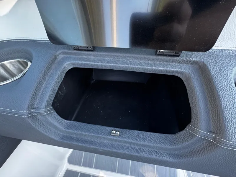 Slide: The Image of Open storage compartment in 2025 Regal LS4 boat with cup holder. - 28