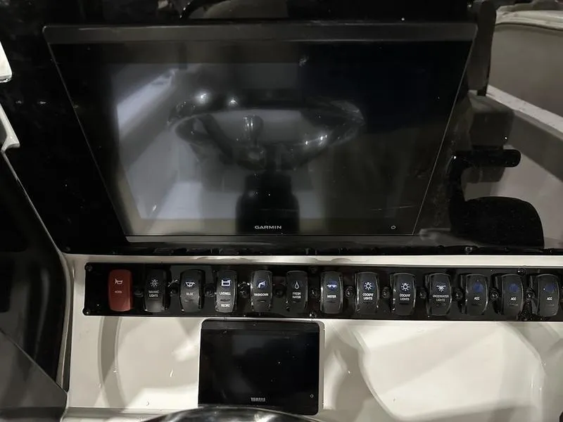 Slide: The Image of 2025 Sea Hunt Ultra 239se dashboard with Garmin display and control switches. - 10