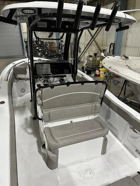 Slide: The Image of 2025 Sea Hunt Ultra 239se boat interior with seating and console in a garage setting. - 6
