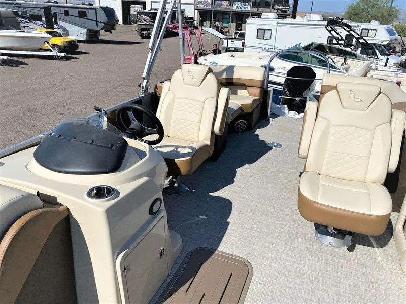 Slide: The Image of 2022 Lowe SS 230 WT pontoon boat interior with beige seating and steering console. - 3