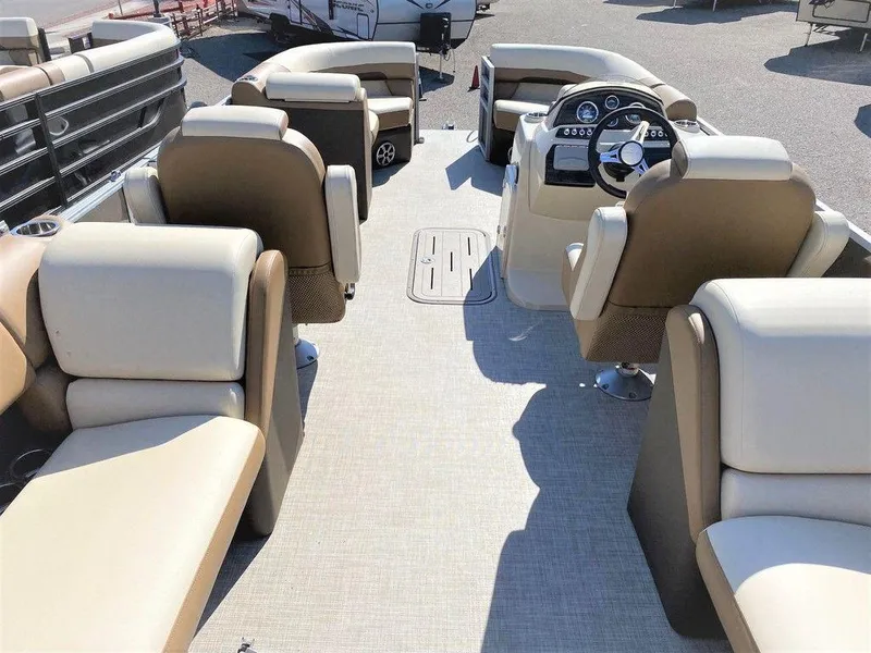 Slide: The Image of 2022 Lowe SS 230 WT pontoon boat interior with beige seating and steering console. - 5