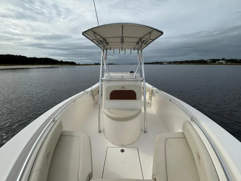 Slide: The Image of 2022 Cobia 237 Center Console boat on calm water under cloudy sky. - 14
